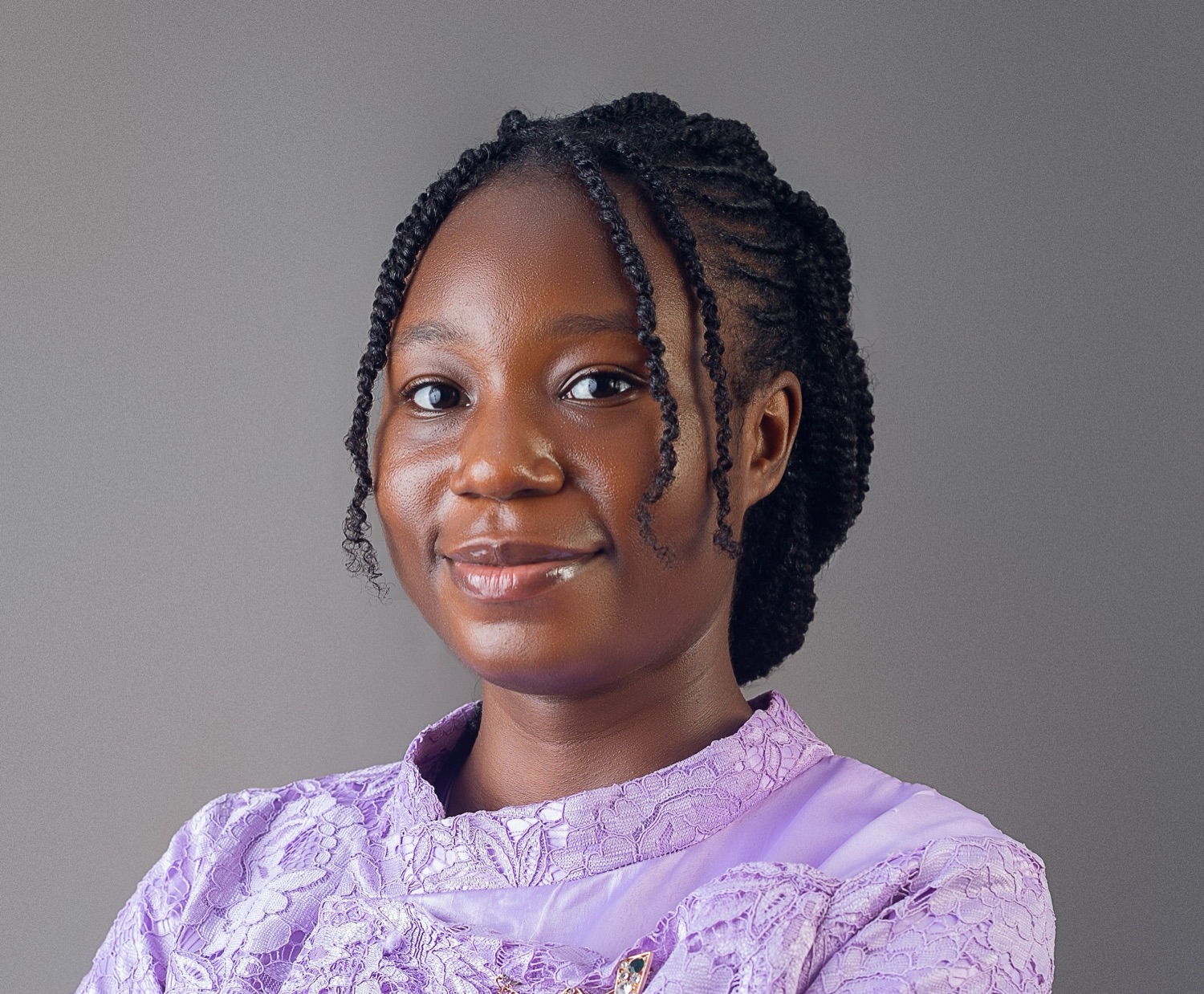 Portrait of Bunmi Akinremi, AI researcher, smiling in a lilac lace top